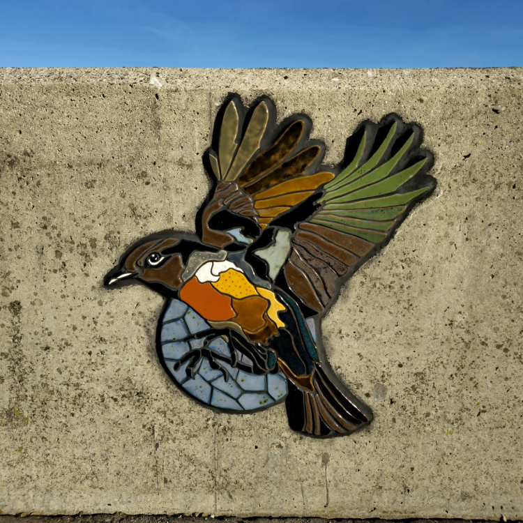 A mosaic rendering of a bird embedded on the coastal wall