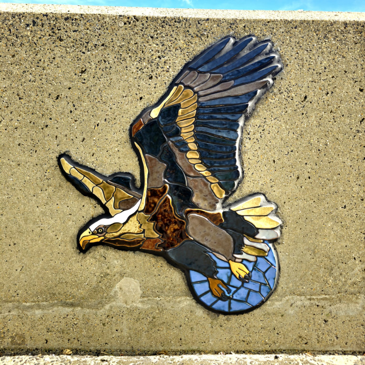 A mosaic rendering of a bird of prey embedded on the coastal wall