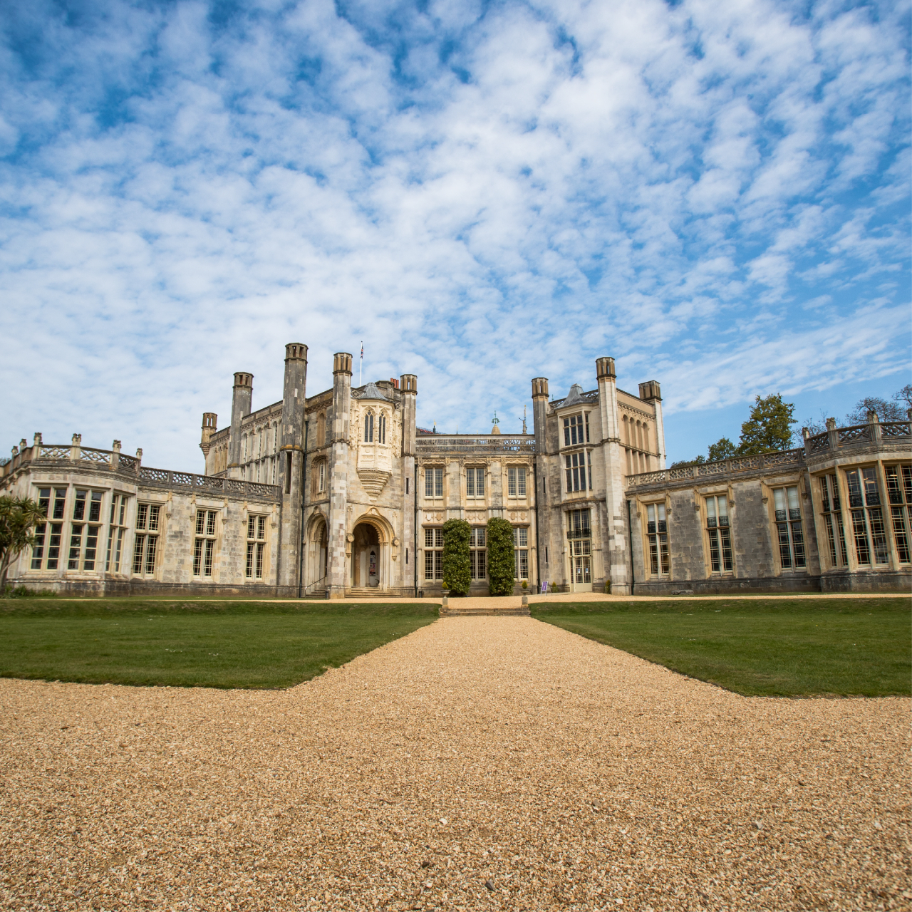 a view of the back facing walls of Highcliffe Castle with the lawn and grounds in the foreground.