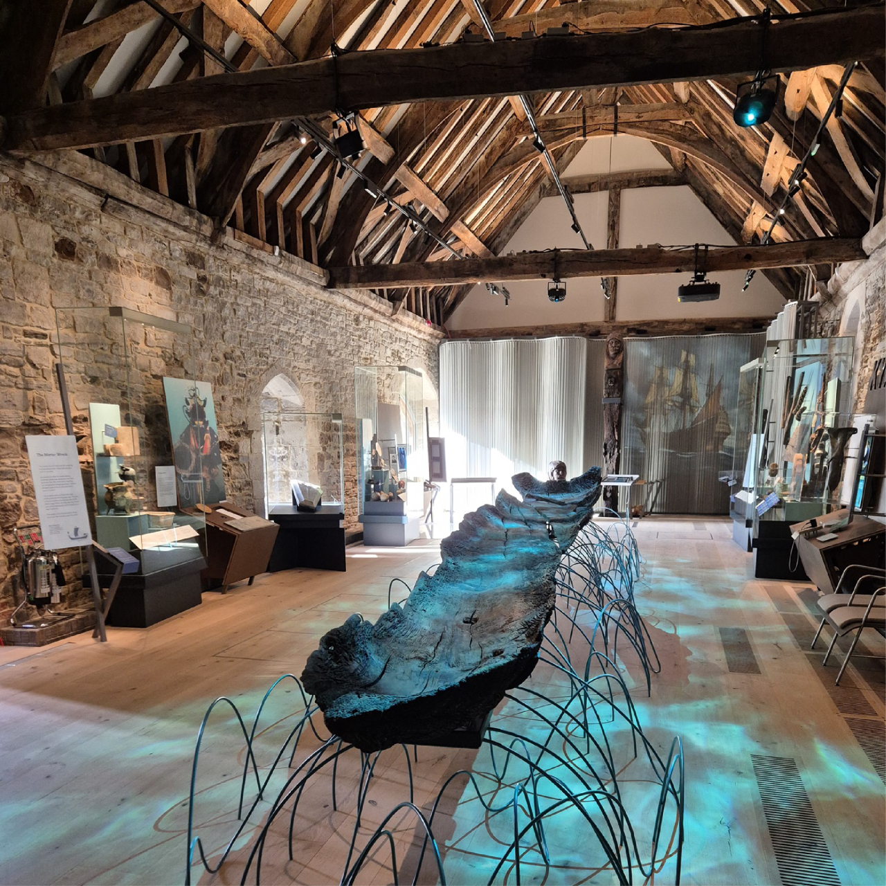 An interior view of a museum display in a traditional building with wooden rafters.