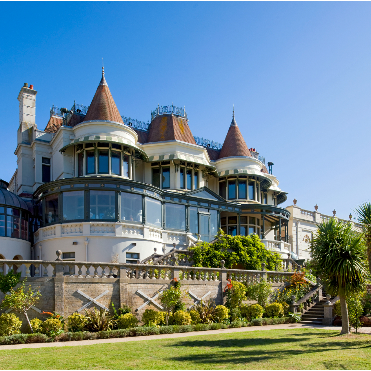 View of the rear façade of the Russell-Cotes museum and the lower lawn behind it.